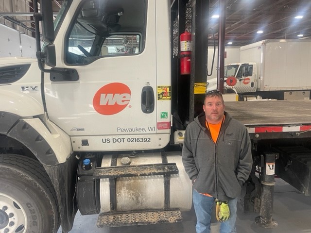 Photo of Craig Walter standing by the door of his We Energies truck.