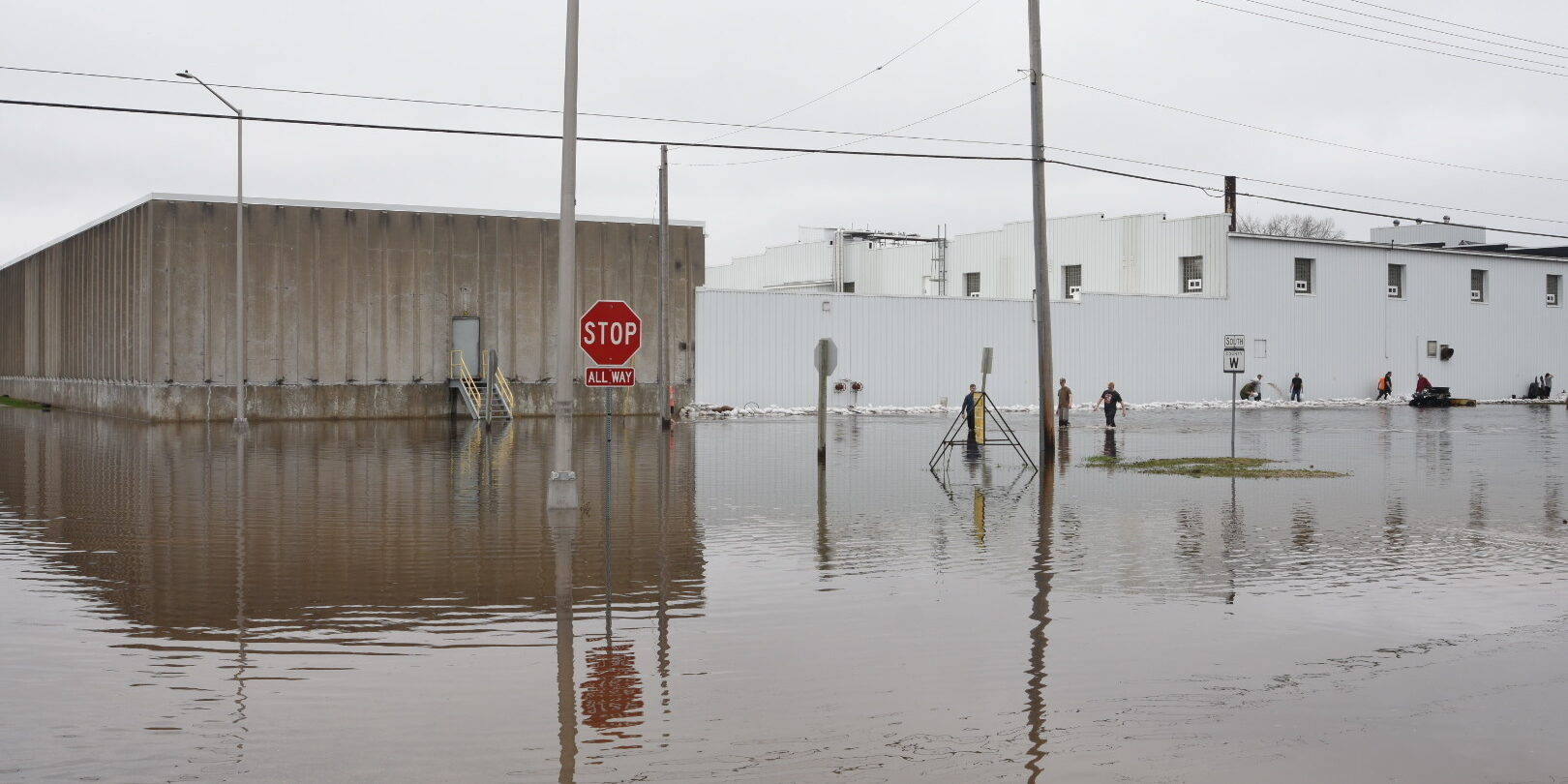 A photo of floodwater covering an intersection in a small city's downtown area.